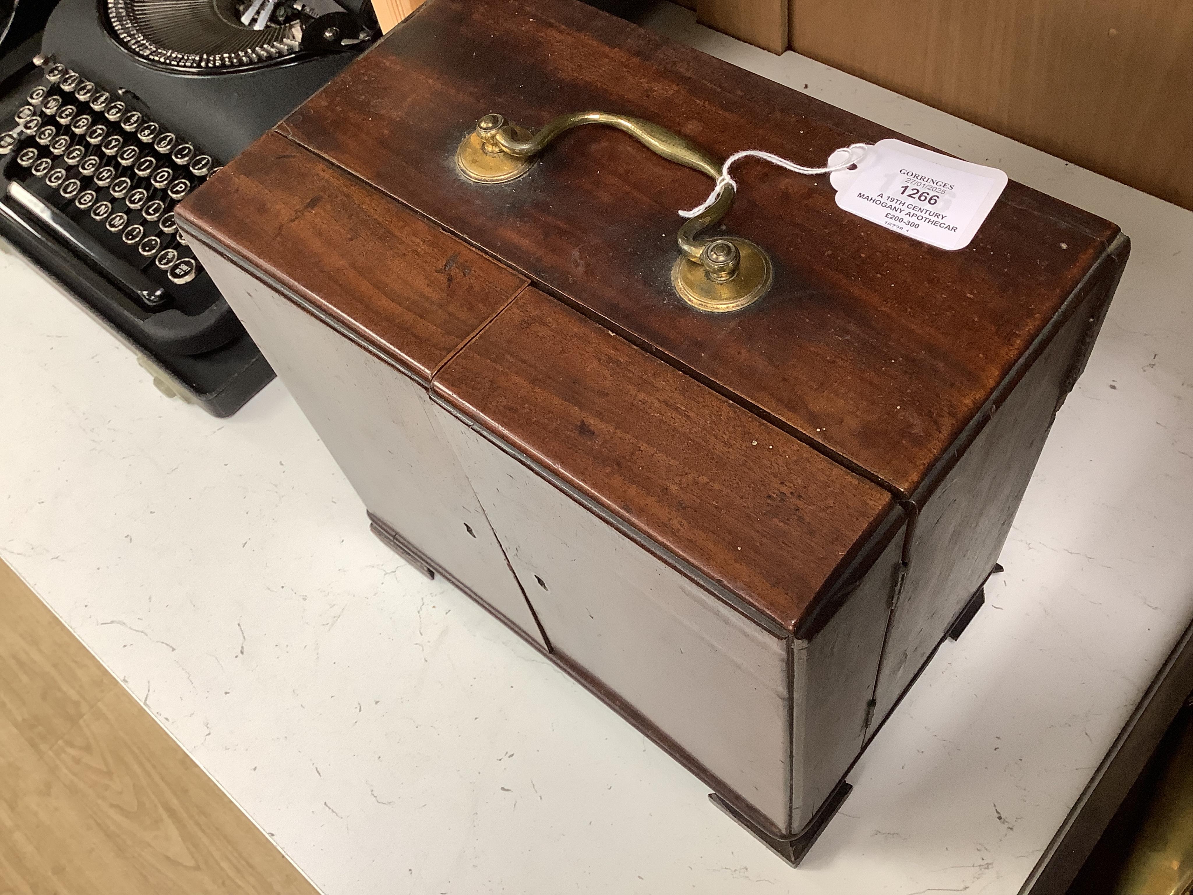 A 19th century mahogany apothecary cabinet, containing 20 bottles of various medicinal compounds and poisons, some sealed, all with paper labels, mainly for ‘C. Woollven, Operative & Dispensing Chemist, 108, High Street,